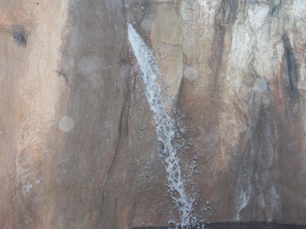 Water falling from hole in cavern ceiling