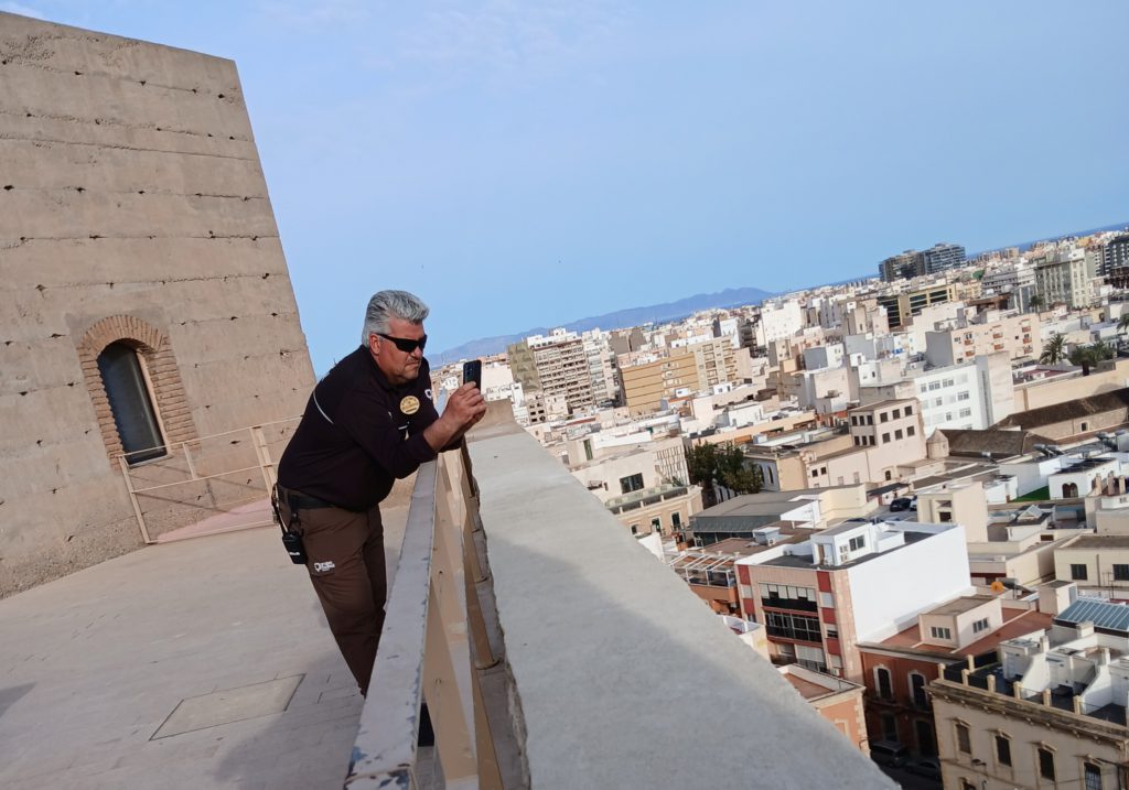 Alcazaba security guard engrossed in his phone instead of scanning the walls for enemies.